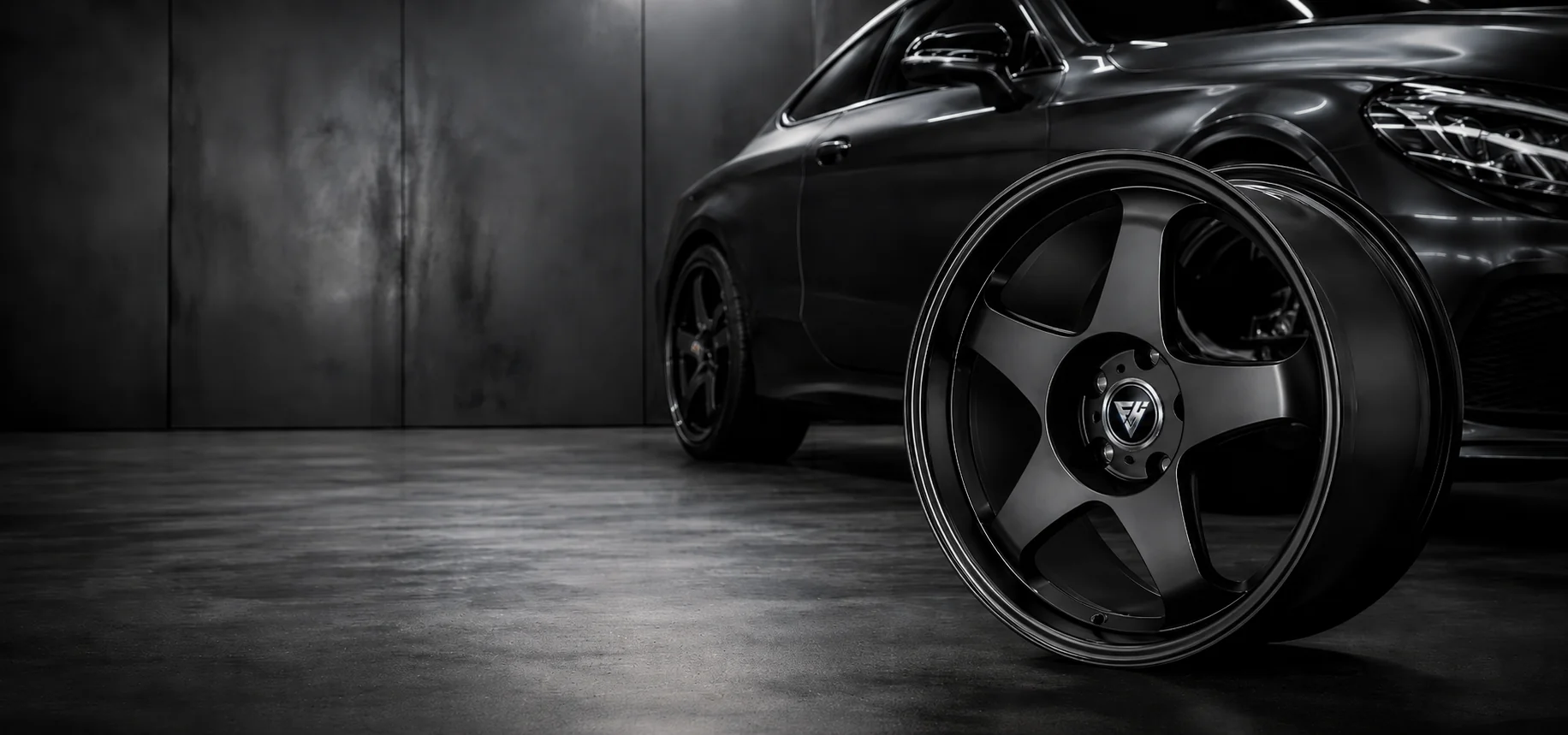 Black performance sedan beside a custom FHJ forged wheel